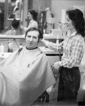 A black and white photograph of the Consitution Hall in the winter with some cars near by.