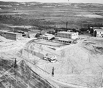 An aerial view of the University of Alaska campus, circa 1937. The three-story structure on the left is Hess Hall and the small house in the foreground was President Bunnell's home. The hockey rink is located behind the president's house. Photo credit: Archives, University of Alaska Fairbanks