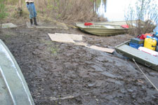 Boats being tied up in a muddy area.