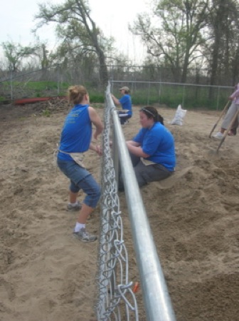 Cynthia Lashinski, Renee Pasker and Kari Pile install a fence at one of the Habitat for Humanity houses. Photo by Clarissa Ribbens