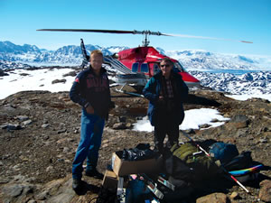 Helicopter with two people standing in front of it