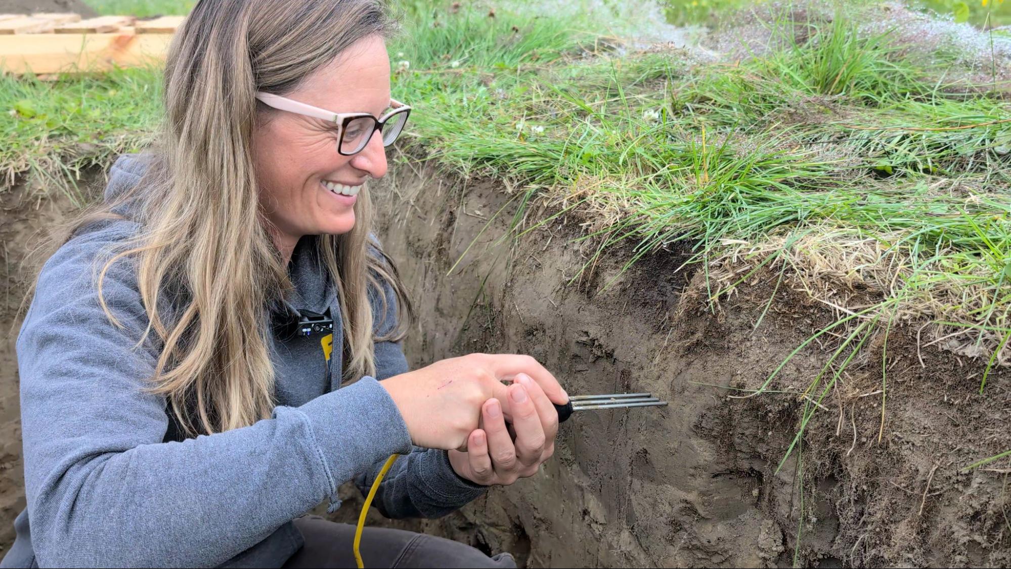 A scientist, Caley Gasch, tests the soil in a field in Alaska.