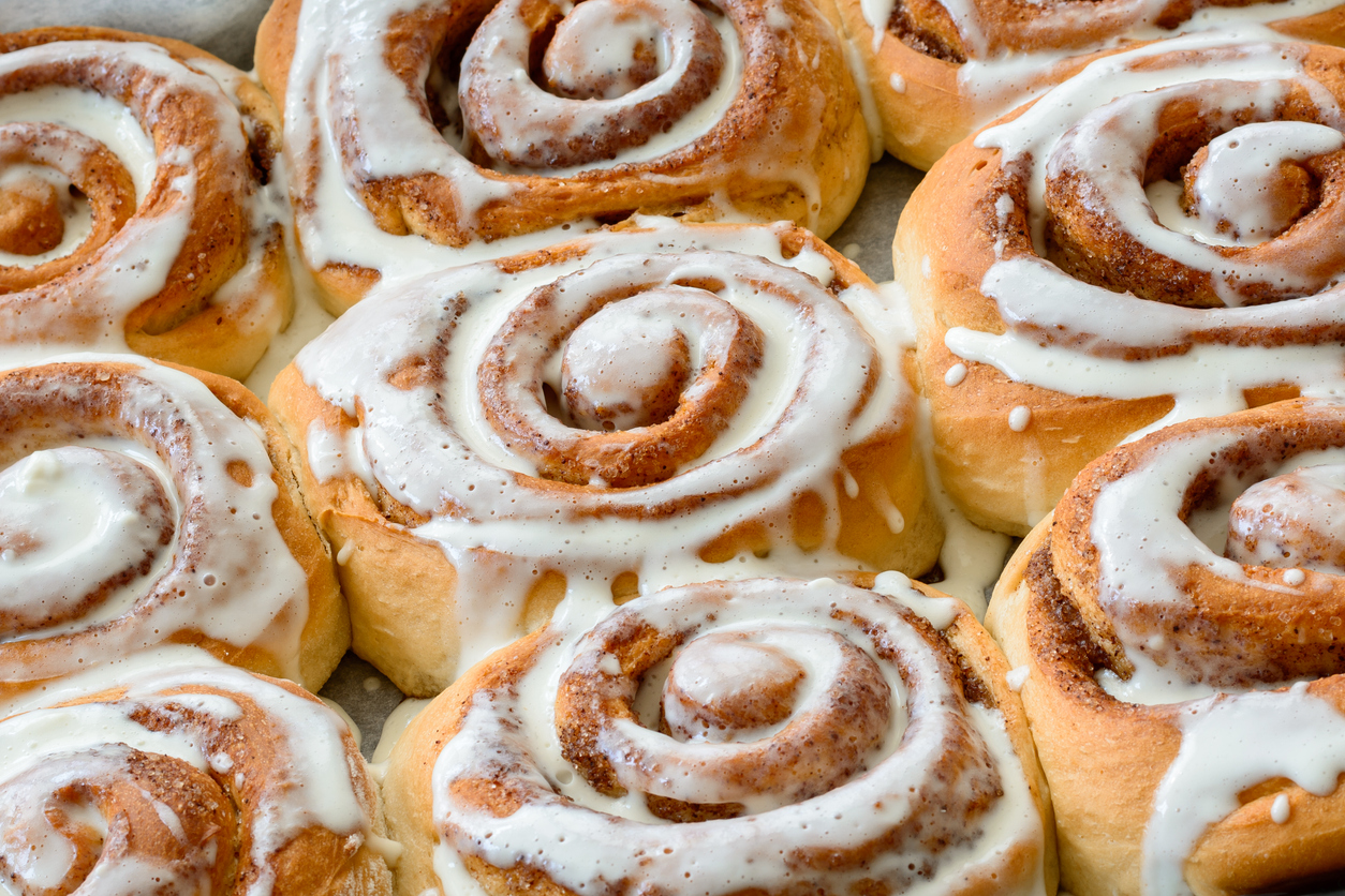 A tray of freshly baked cinnamon rolls with icing