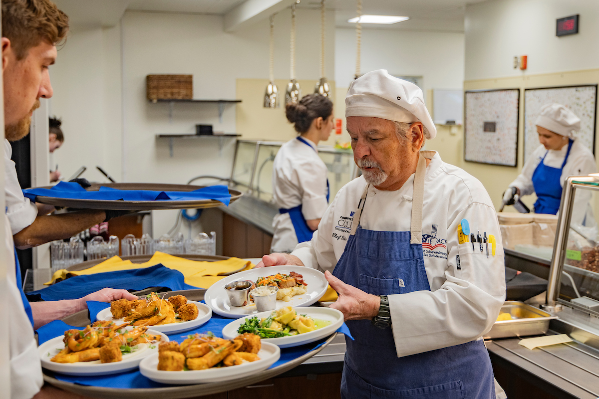 A UAF Community and Technical College culinary arts program faculty and student prepare food on trays. 