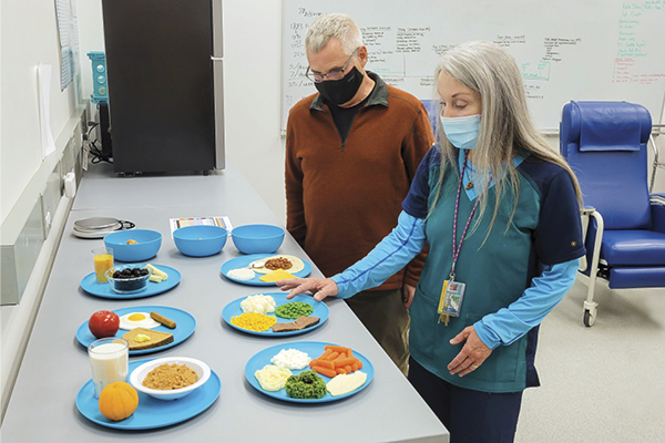 Two people looking at plates of food.