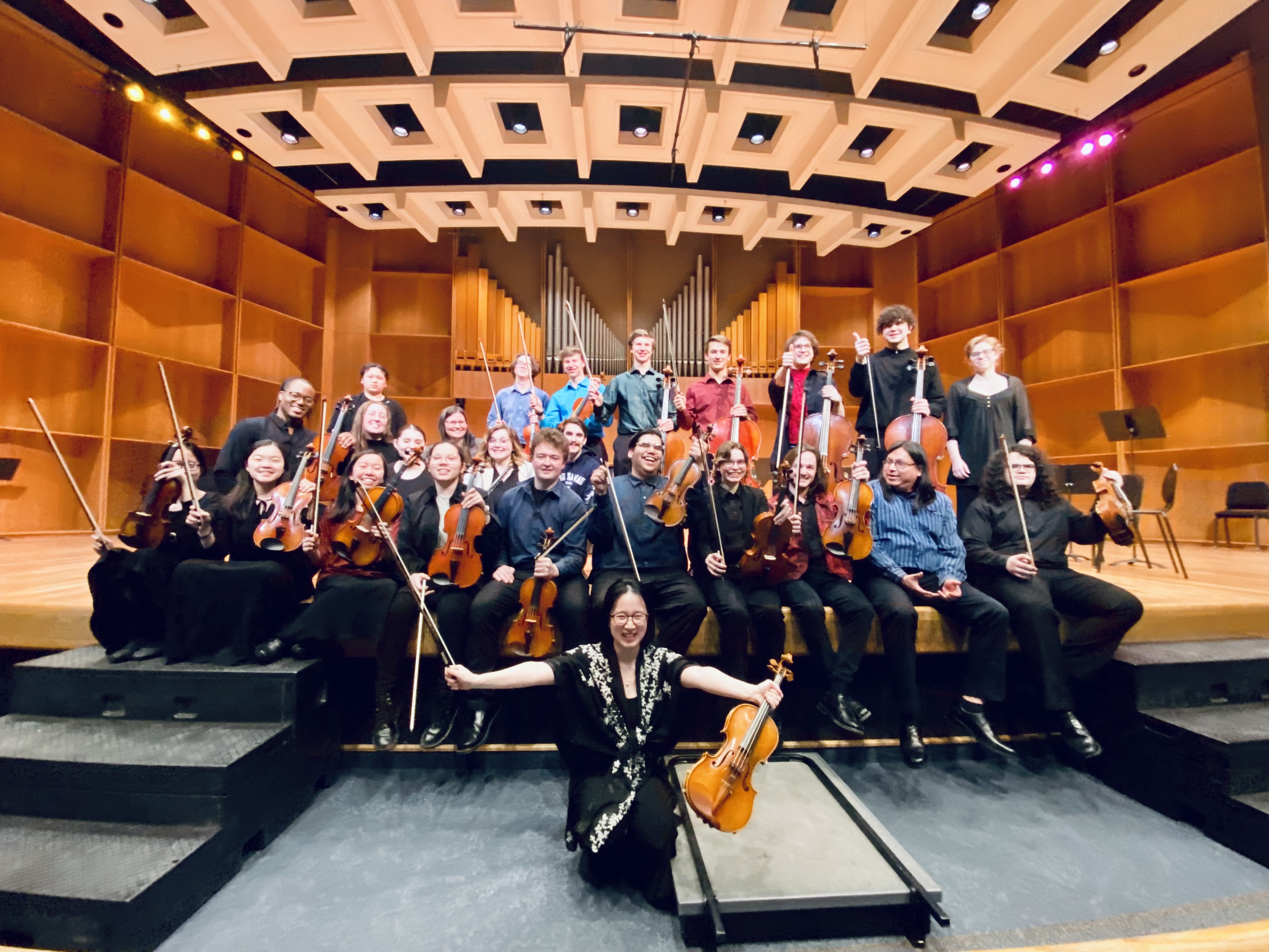 Northern Lights String Orchestra members pose for a photo with their conductor, Yue Sun (center), after a concert in the Davis Concert Hall on April 22, 2022.