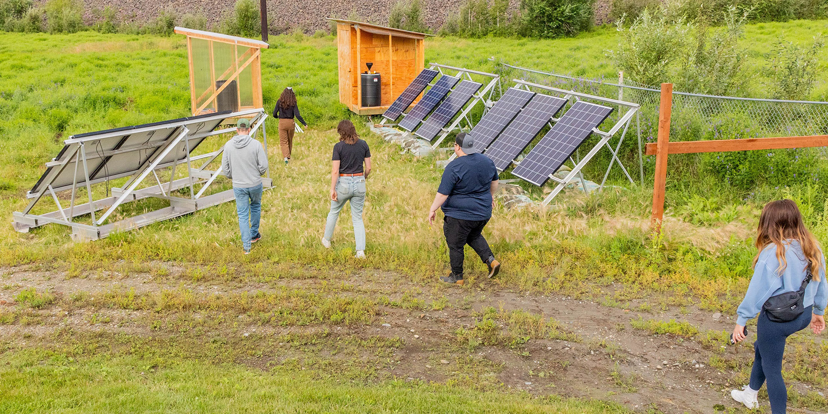 People walking by solar panels