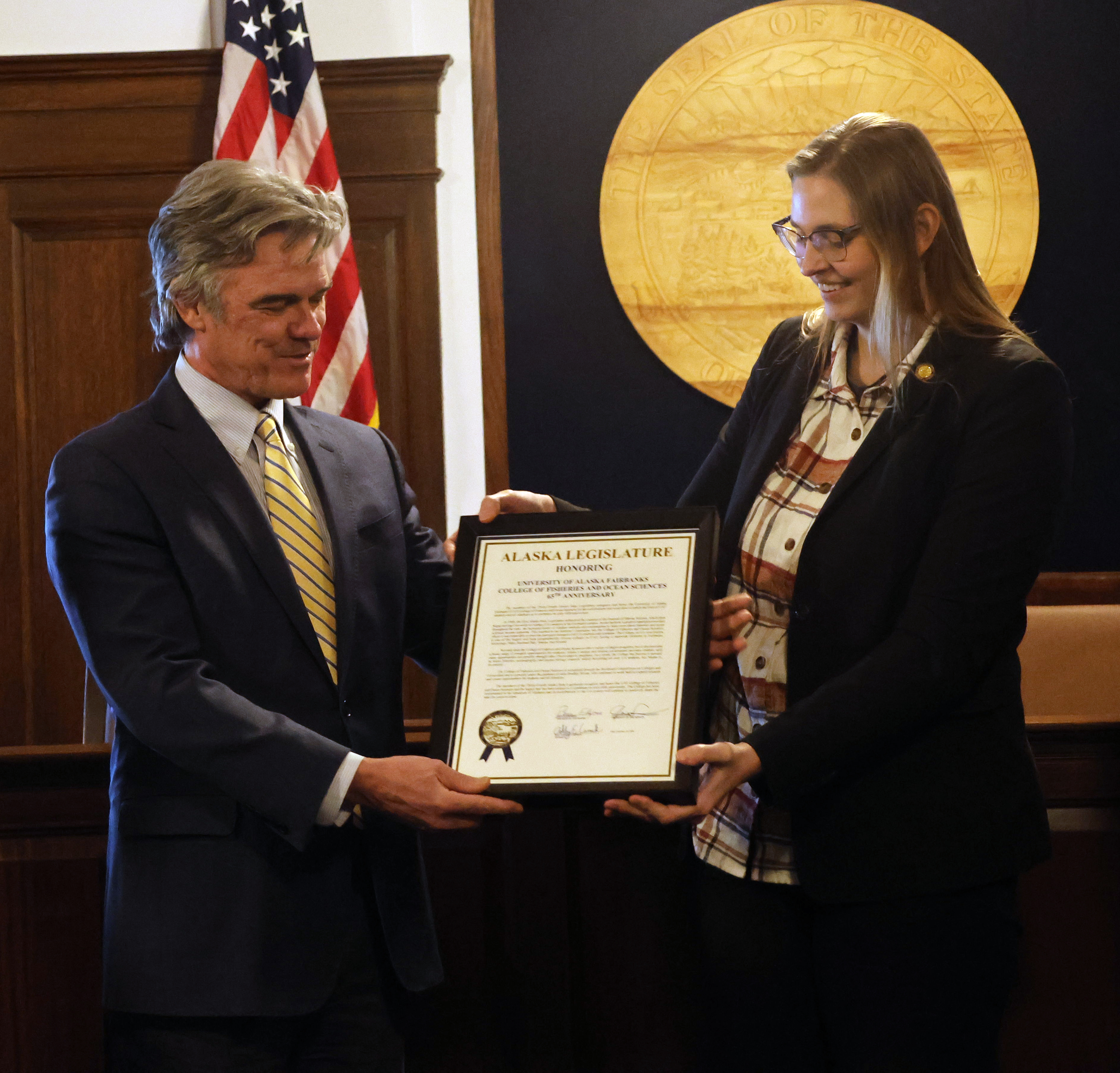 Dean Bradley Moran and Rep. Ashley Carrick display a legislative citation recognizing the 65th anniversary of the College of Fisheries and Ocean Sciences.
