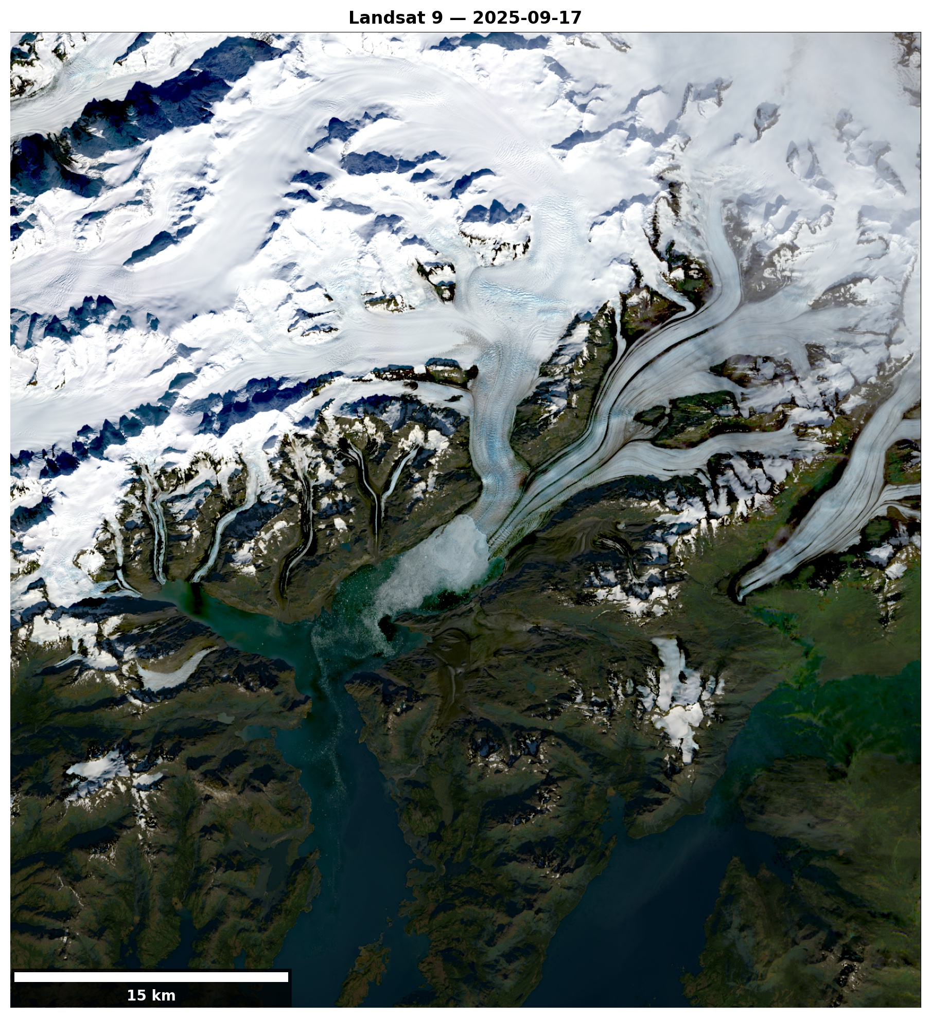 A Landsat 9 satellite image shows Columbia Glacier in southern Alaska on Sept. 17, 2025, with bright white ice fields flowing through rugged, dark mountains and branching into long glacier tongues that end in a blue-green fjord. Snow-covered peaks surround the glacier, and meltwater and sediment tint the coastal waters below. 
