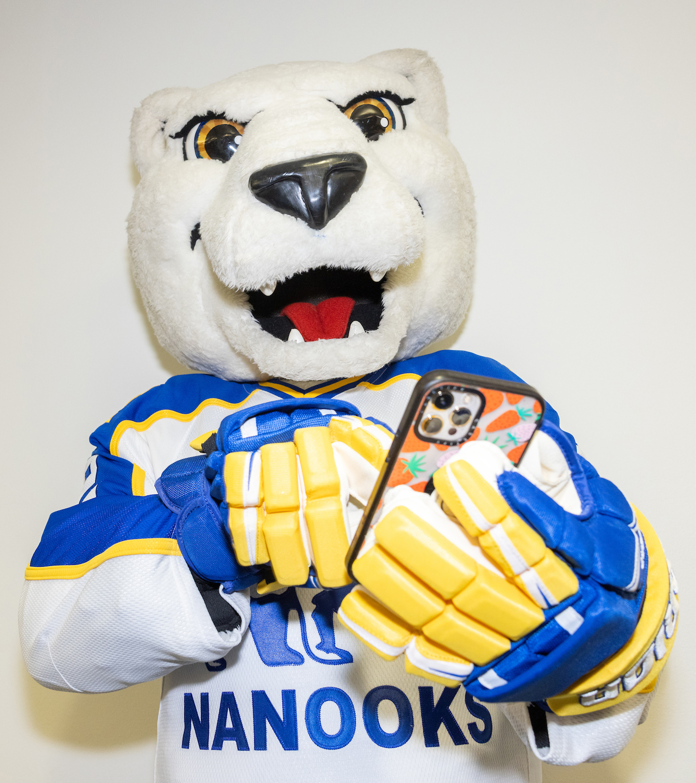 Nook, the UAF polar bear mascot, uses the Navigate mobile app to check for updated information on his UAF classes.