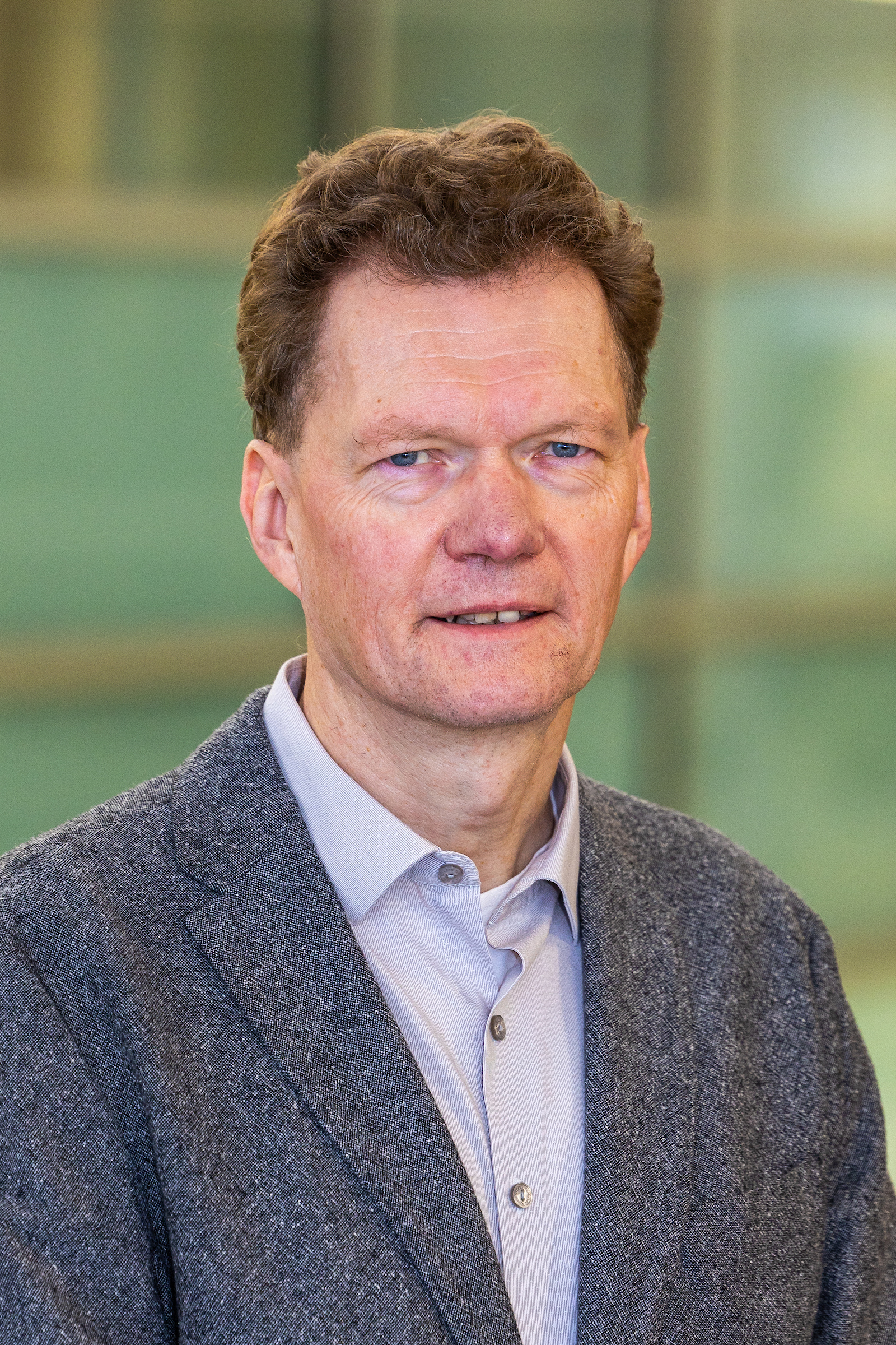 A portrait of a person wearing a grey sport coat