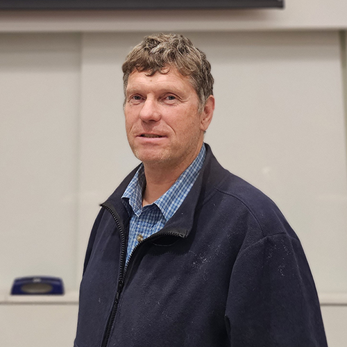 A man stands in front of a projected image of a great gray owl.