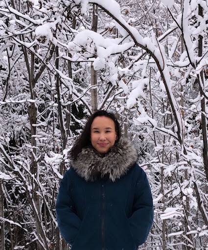 Headshot of Roberta Glenn standing in front of a stand of snowy trees.