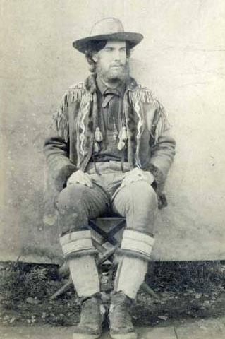 Black and white photo of a man wearing animal hides and furs