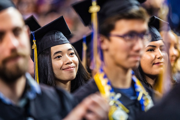 Ajiel Mae Basmayor, who earned a bachelor’s degree in biological sciences, listens to class speaker Jessica K. Obermiller during the University of Alaska Fairbanks’ 97th commencement ceremony on May 4, 2019, at the Carlson Center.