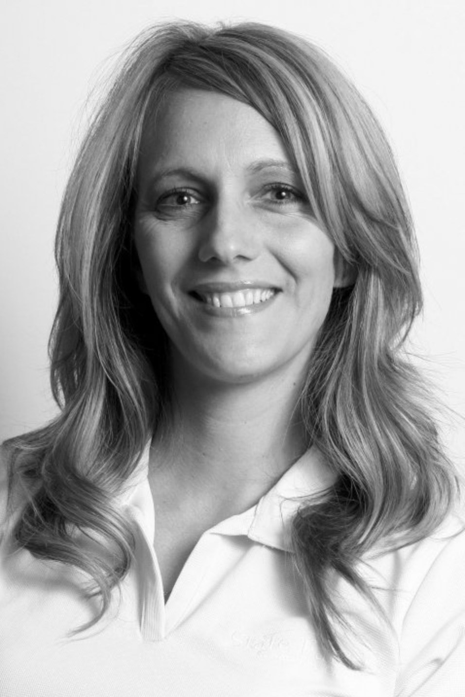 Black and white photo of a smiling woman with long hair