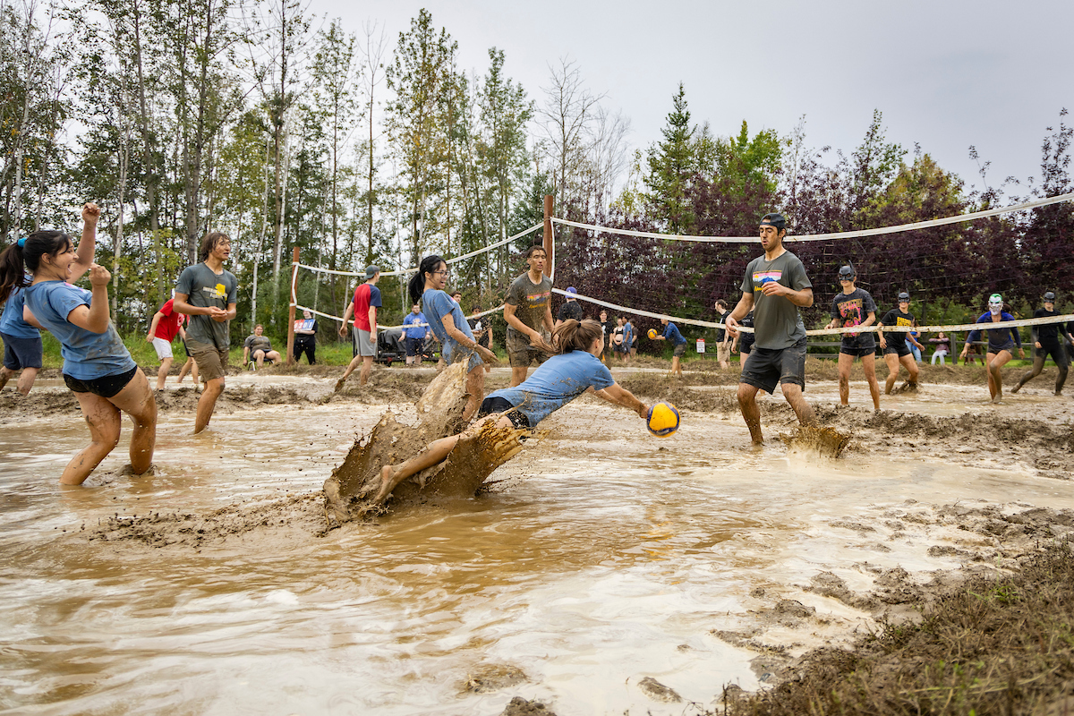 Students participate in a mud-volleyball game. The ever-popular mud volleyball started as mud hockey in the late 1950s.