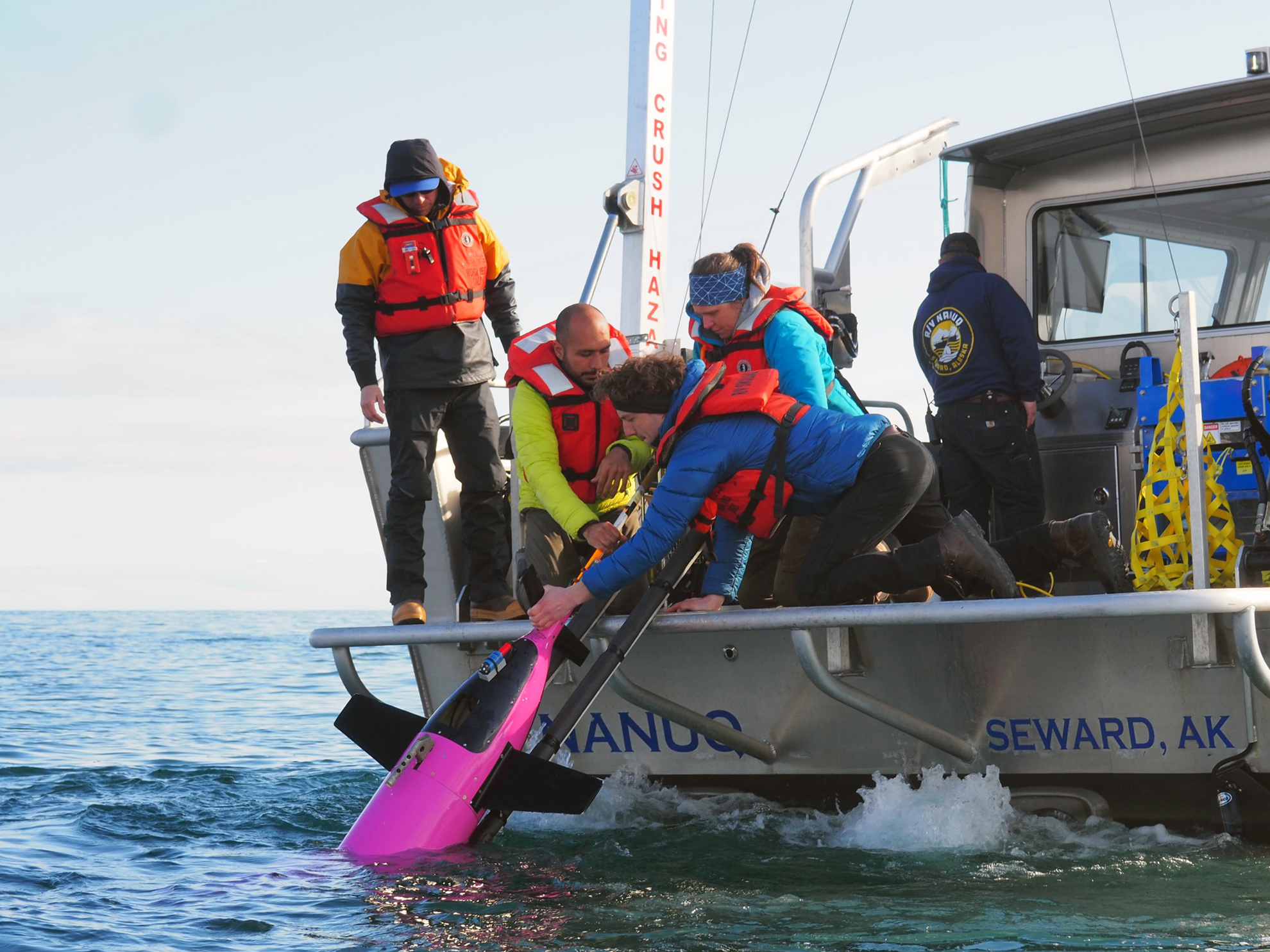Scientists and their industry partners pull a carbon dioxide-measuring Seaglider out of the water in the Gulf of Alaska.