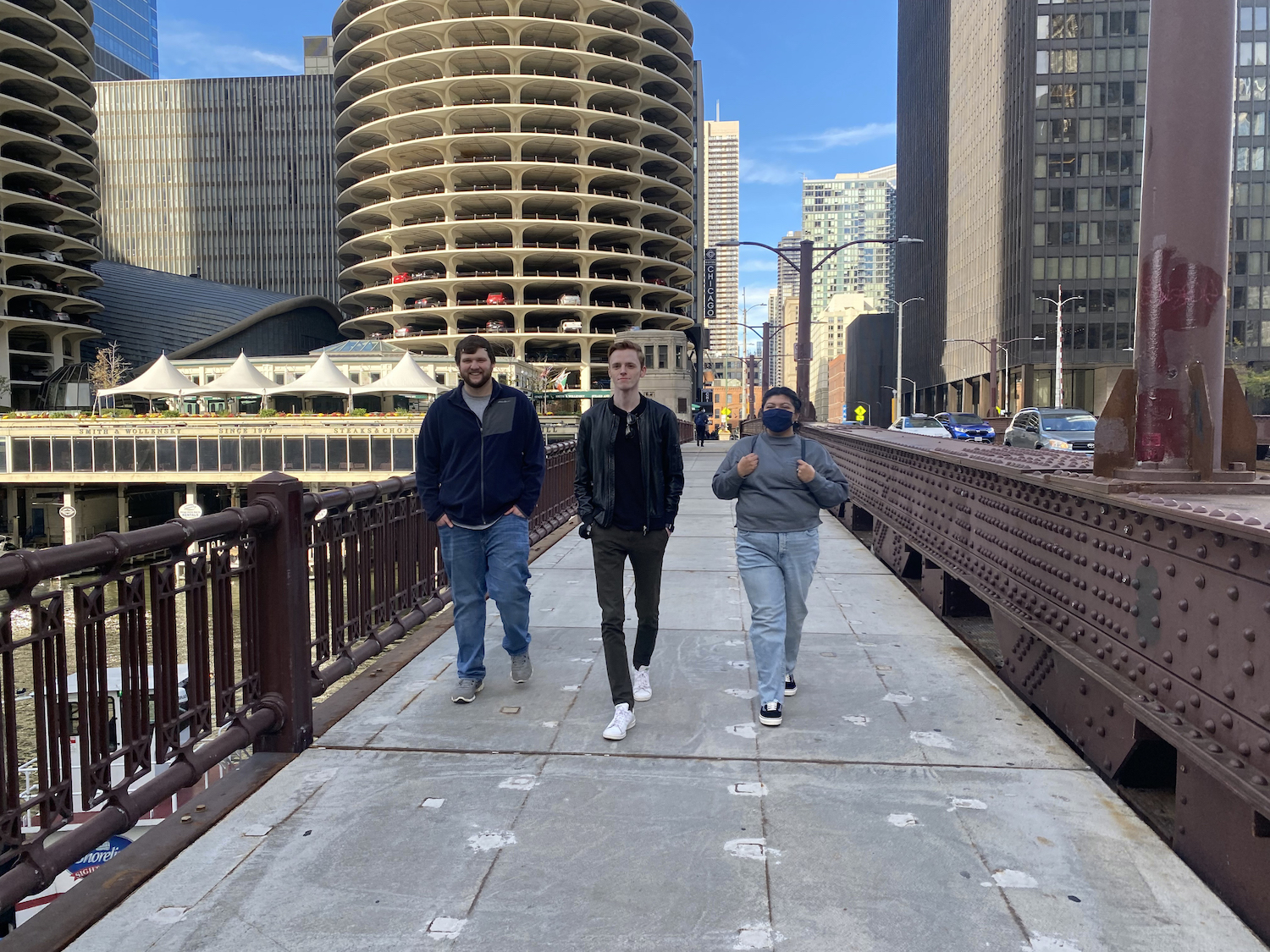 Students Nikolai Unruh, Jenifer Garcia and Bryan Sauer walk across the State Street bridge over the Chicago River. 