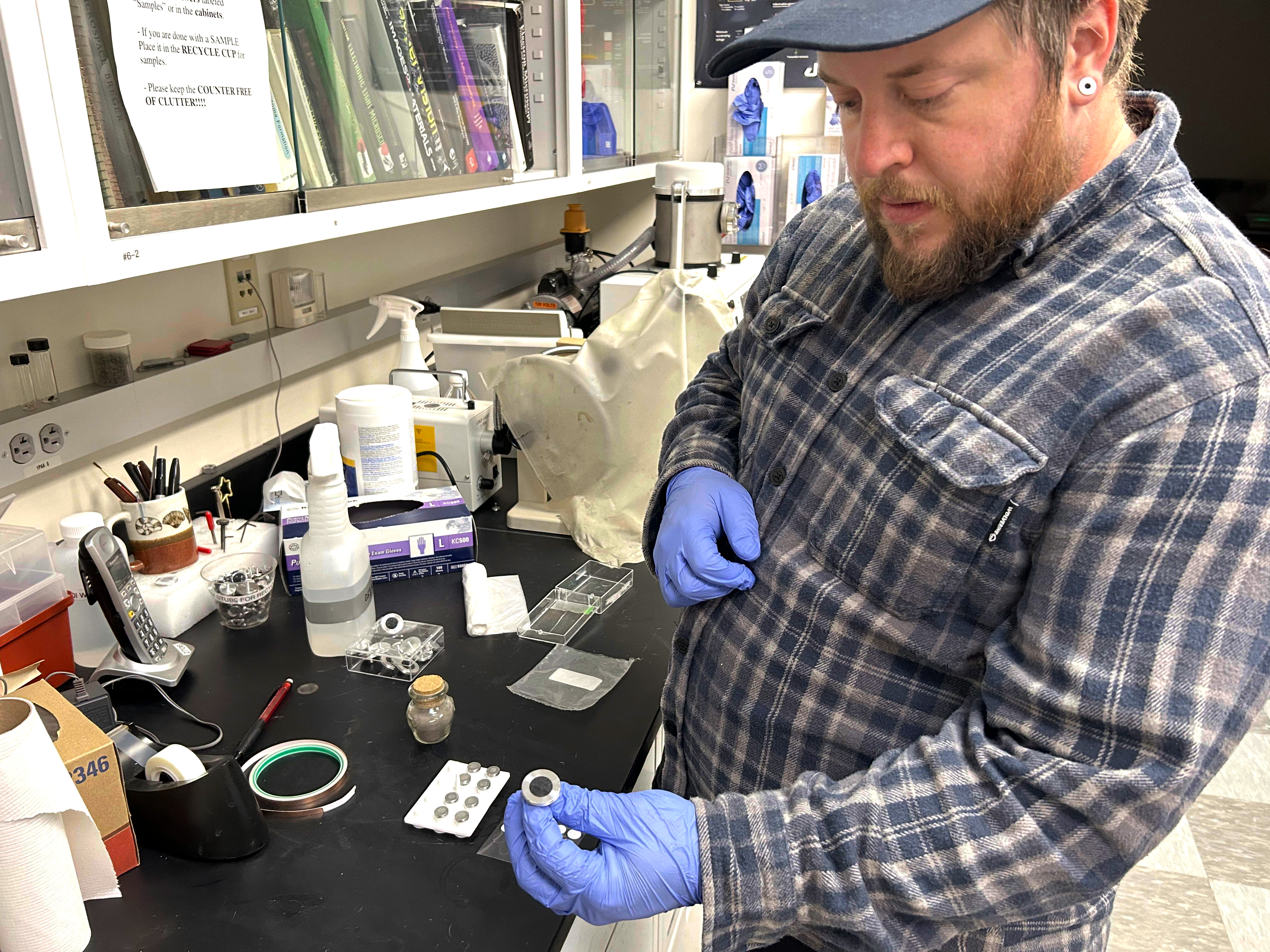 a person holds a bottle of ash in a lab