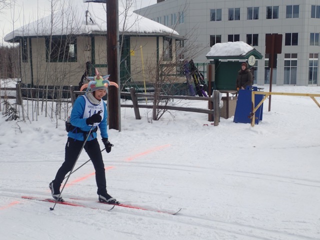 A skier in a colorful hat crosses a line spray-painted in pink on the snow.