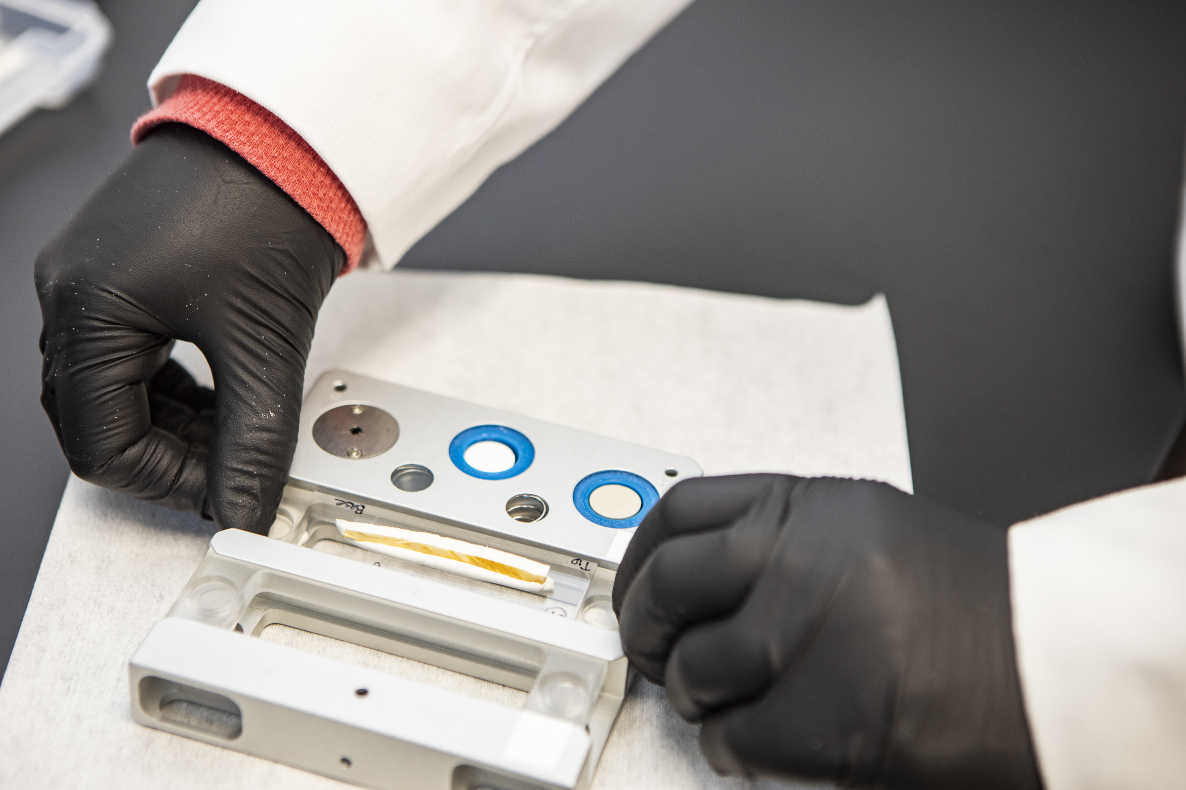 A person's hands arrange a bone segment in an instrument.