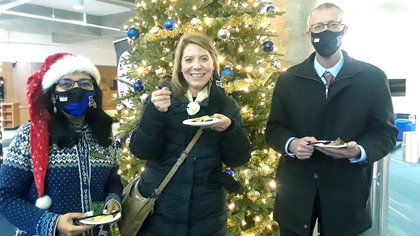 Three people holding plates of food