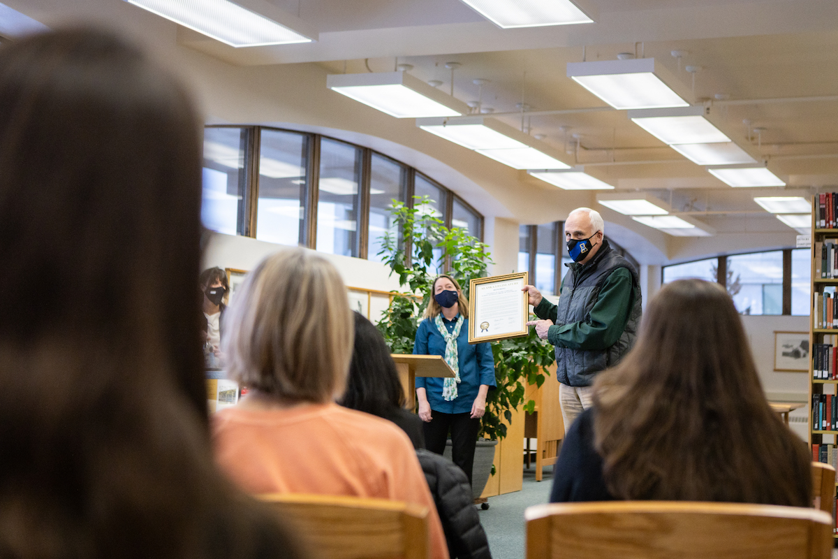man holding framed citation
