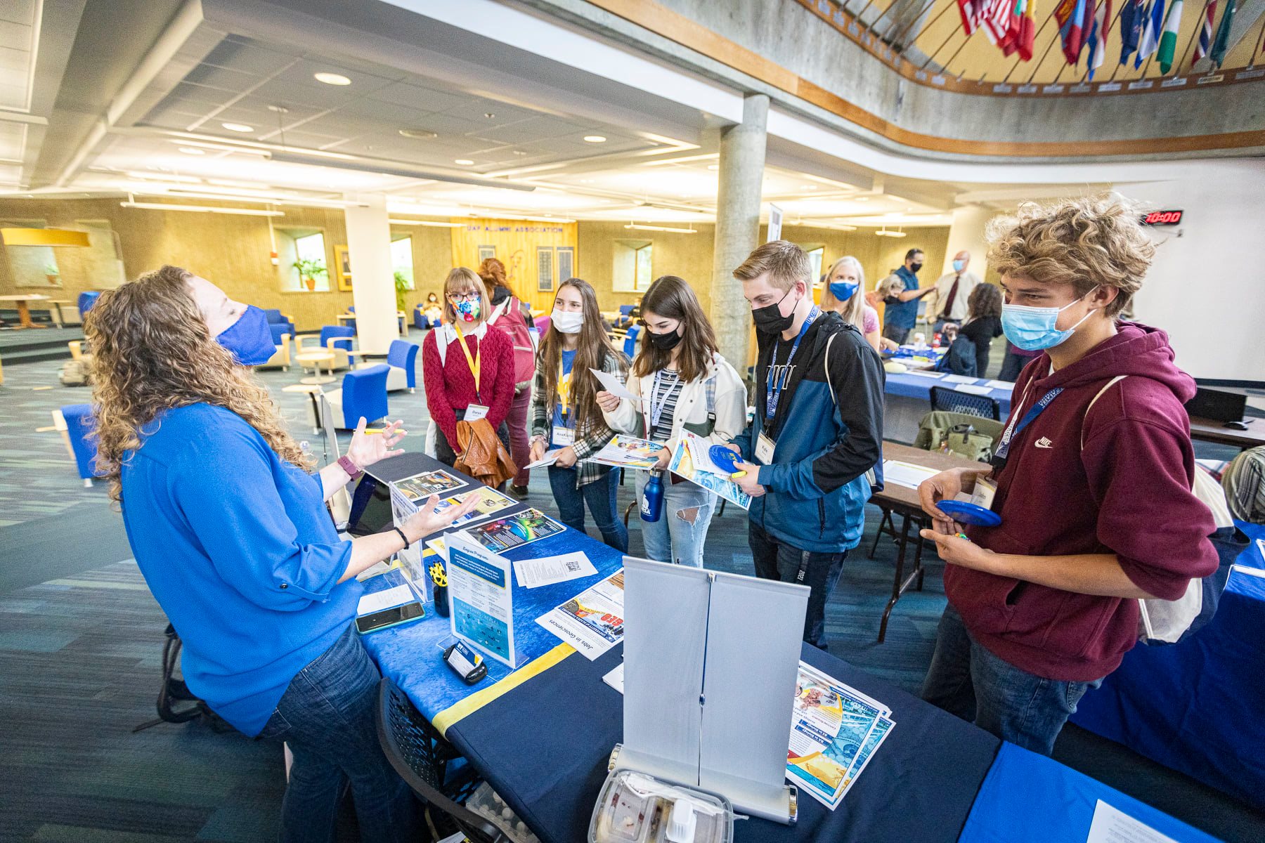students picking up flyers from a table