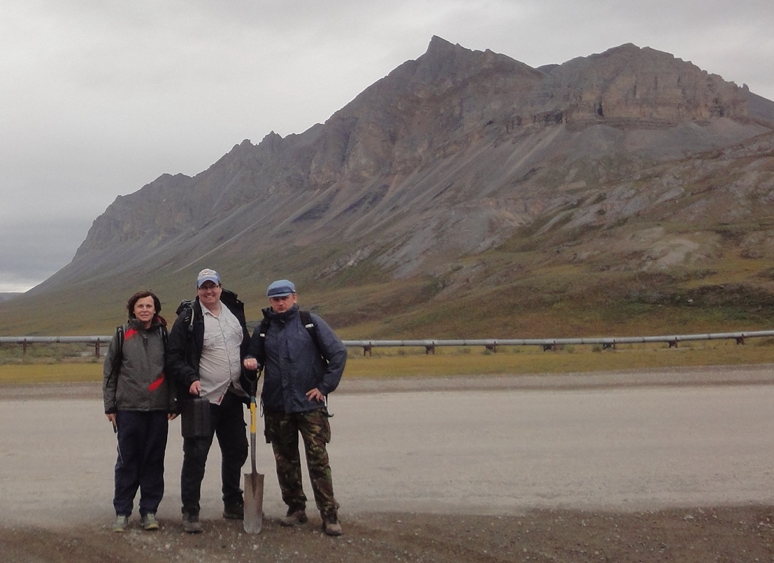 Researchers standing on a gravel pad in the Brooks Range with field gear