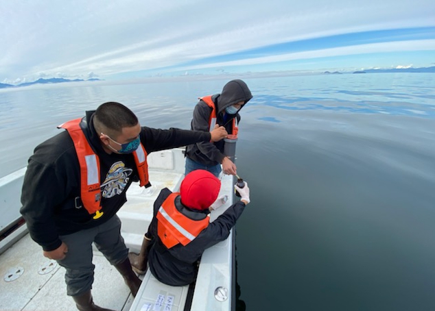 Simon Friday (back) and two other local residents gather water samples during the Kake Climate Partnership.