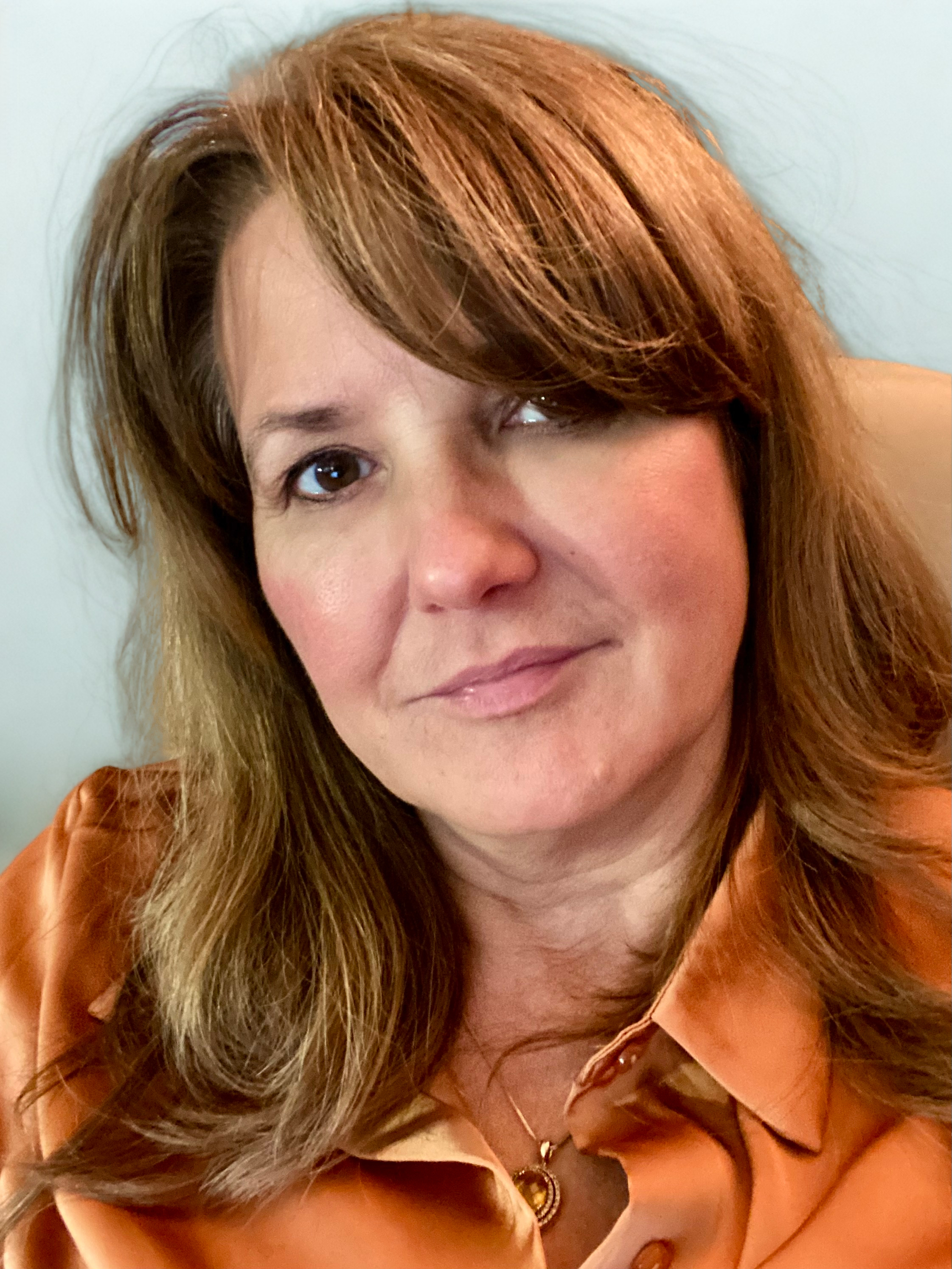 A woman wearing an orange blouse.