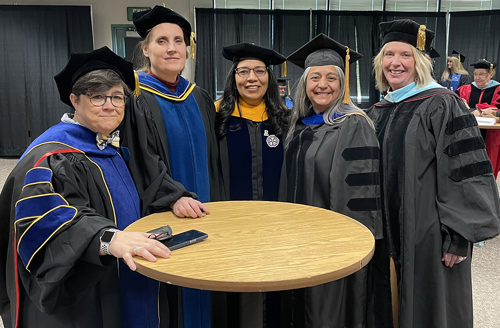 UAF faculty pause for a photo with Provost Prakash before a commencement ceremony.