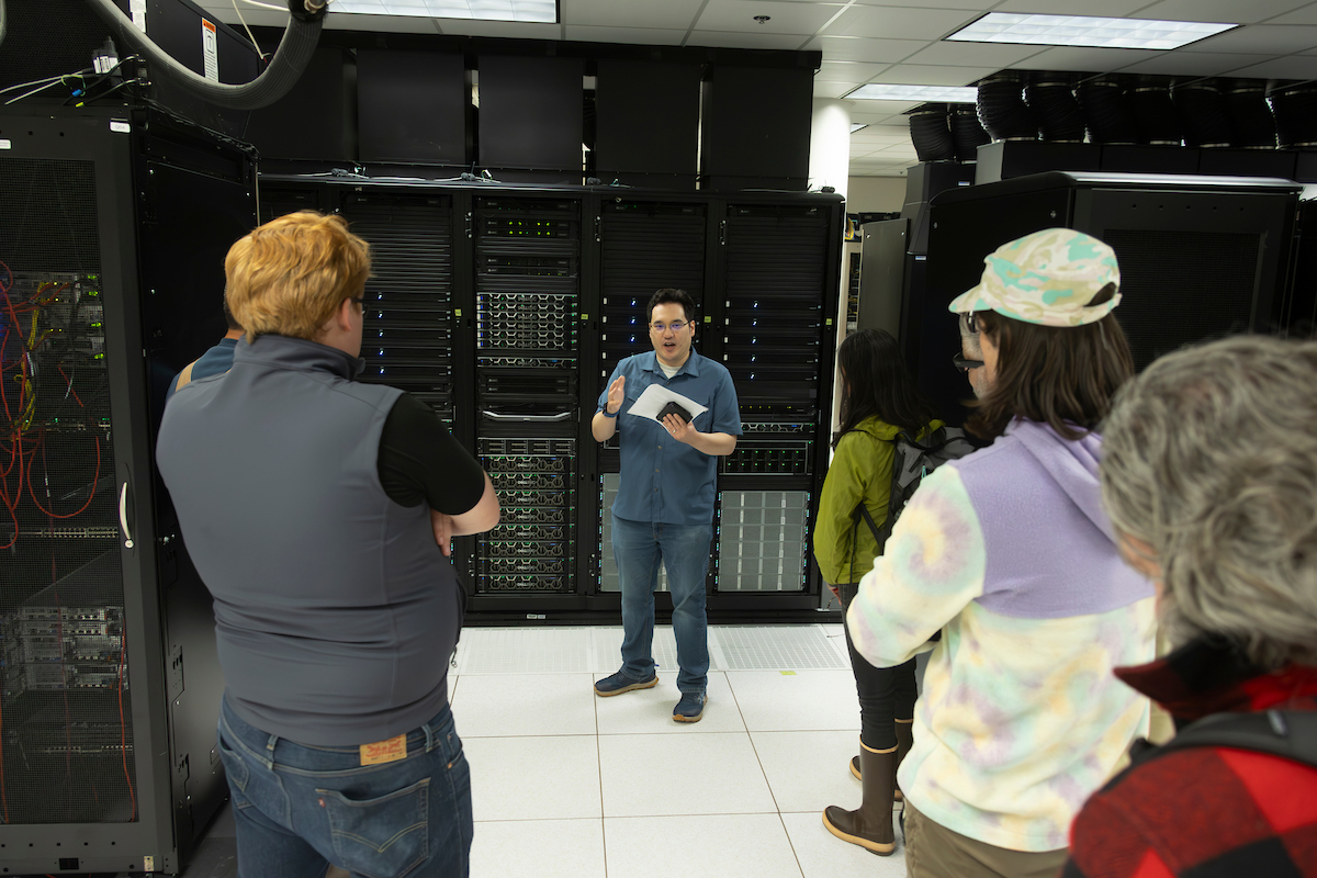 A person is talking to a group of people at a data center.