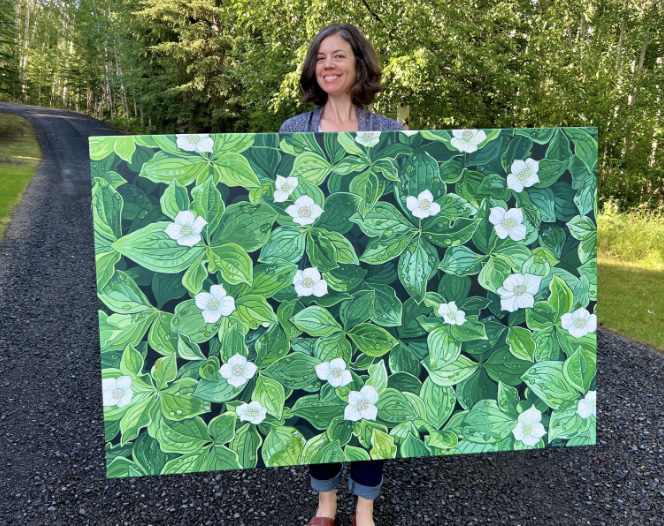 Gail Priday holding one of her paintings.