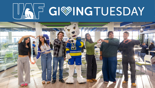 Student and the Nook mascot post for a Giving Tuesday photo at UAF.