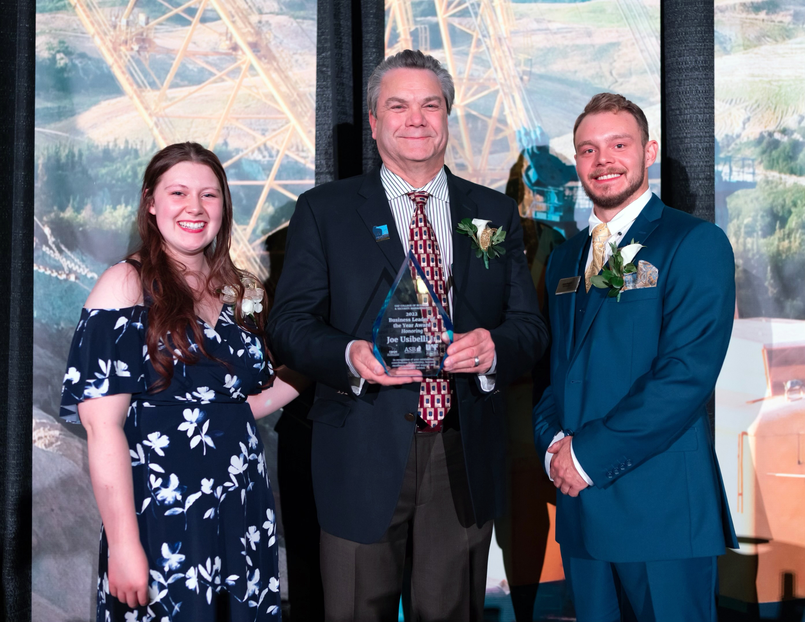 Business Leader of the Year committee co-chair Ashley Plys, recipient Joe Usibelli Jr. and committee co-chair Gavin Meggert pose at the BLOY event on Friday, Nov. 18, 2022.