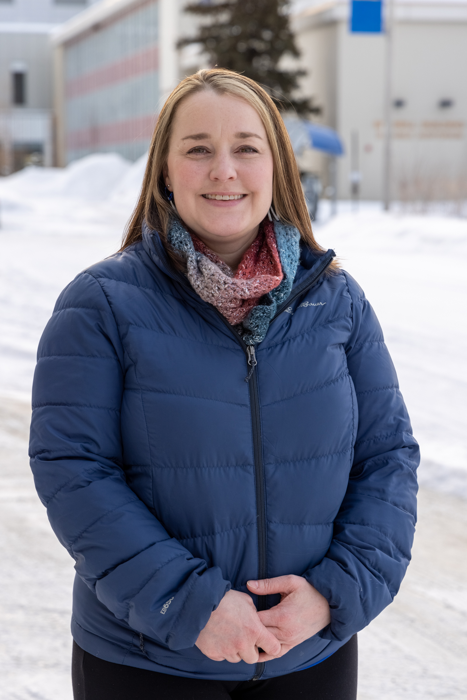 A woman wearing a blue puffy jacket outdoors in winter