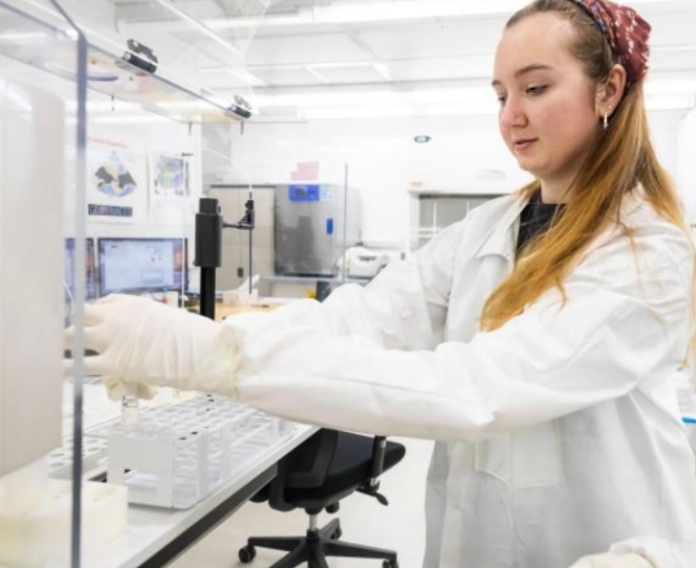 An undergraduate UAF student places samples in a mass spectrometer. UAF photo by JR Ancheta.