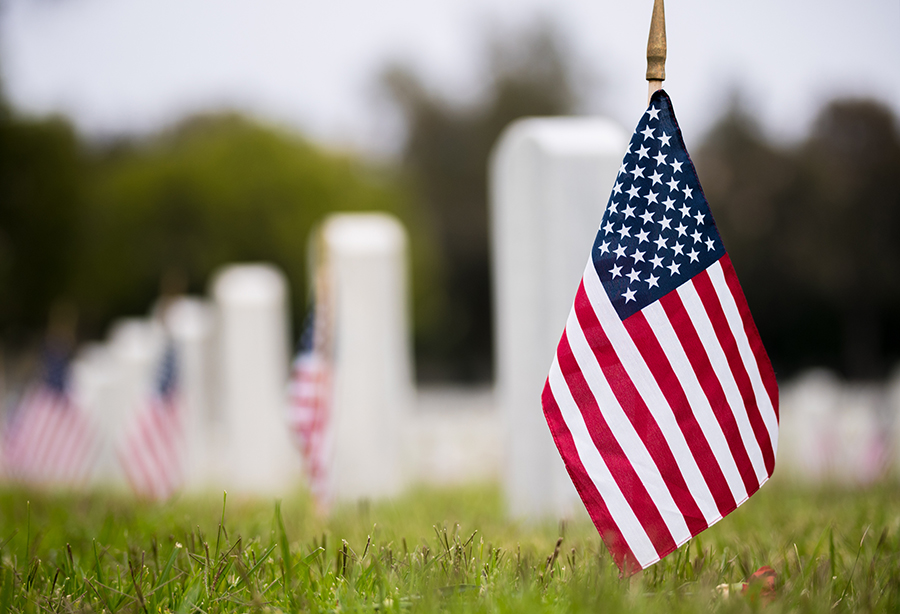 Small American flags and headstones at Arlington National Cemetery during a Memorial Day display.