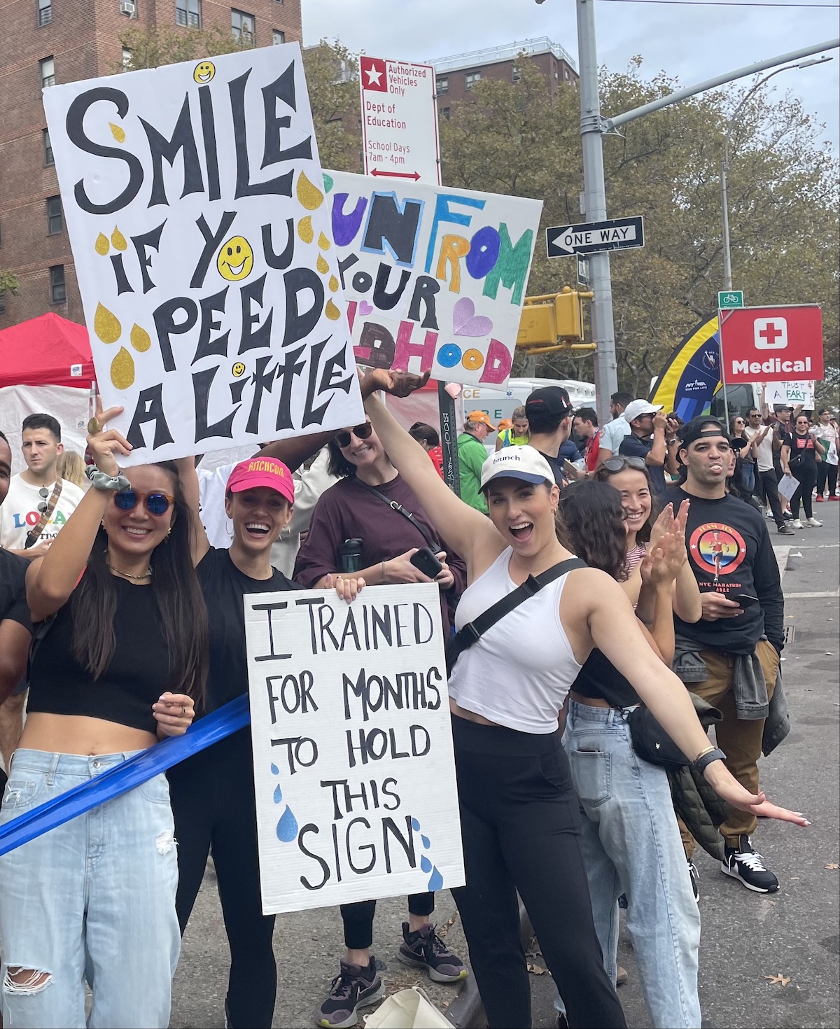Spectators along the New York City Marathon route hold signs reading "Smile if you peed a little," "Run from your childhood" and "I trained for months to hold this sign."