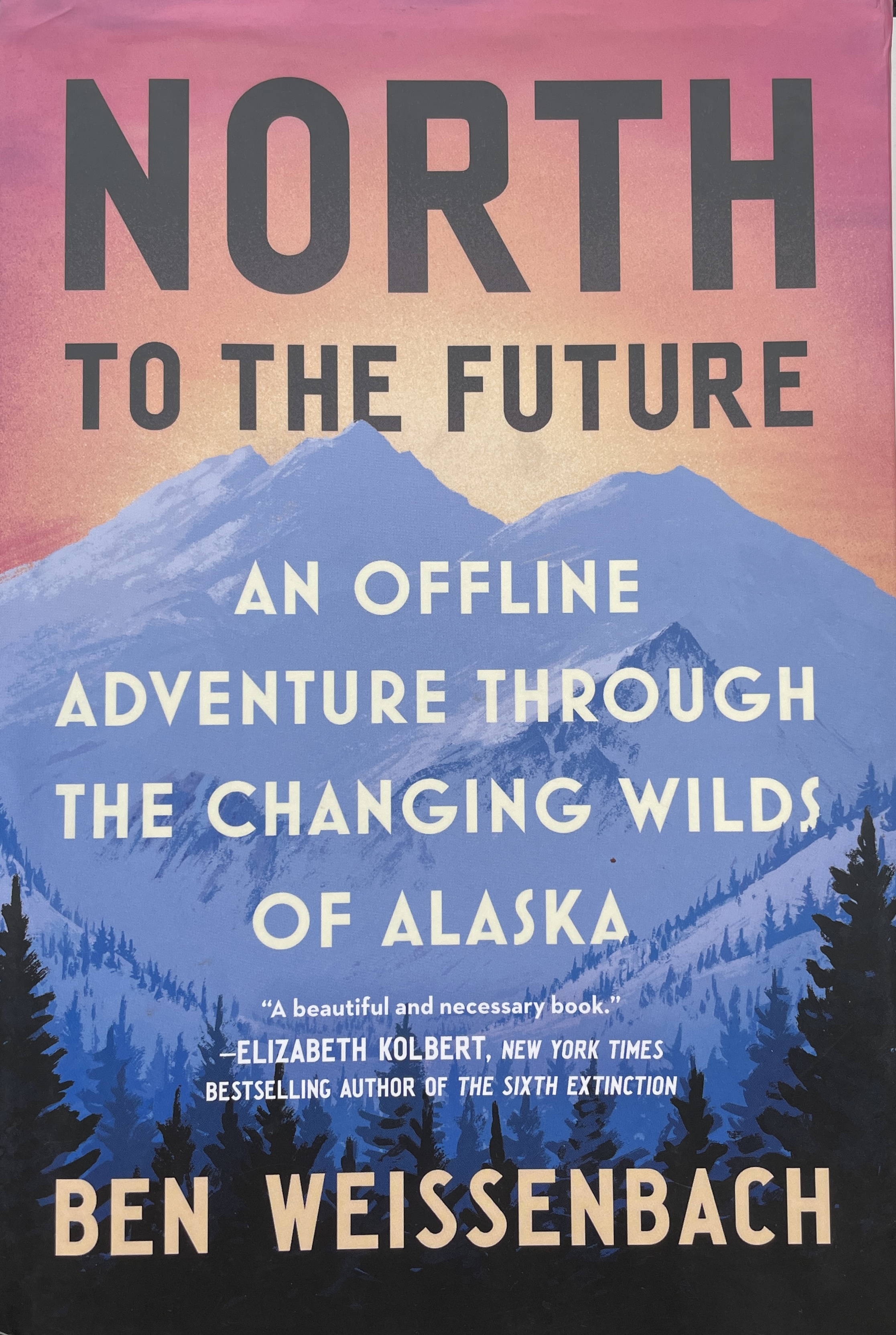 The cover of a book featuring a graphic representation of snow-covered mountains against a sunrise or sunset sky. The cover reads: North to the Future, an Offline Adventure through the Changing Wilds of Alaska. 