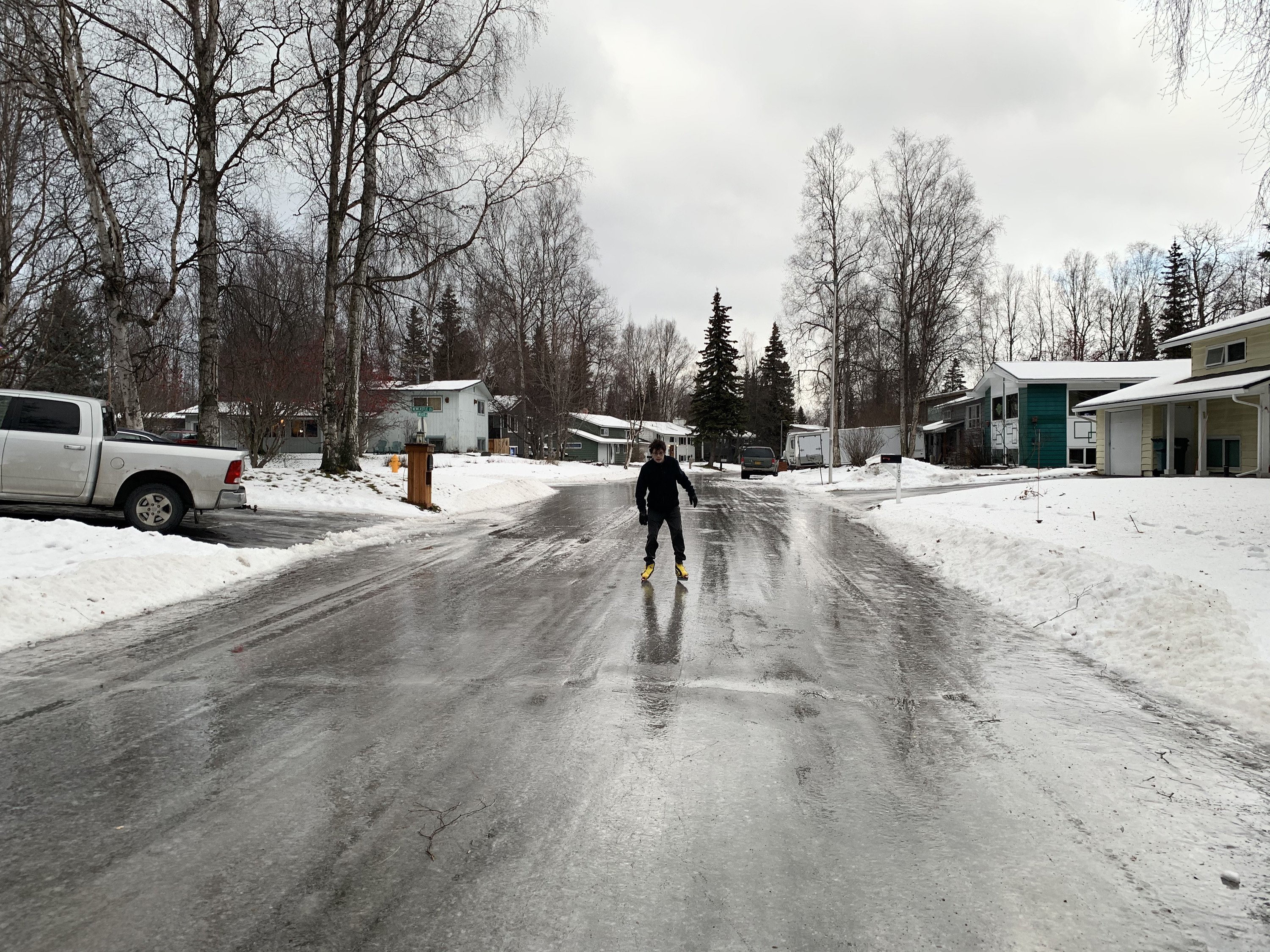 A person ice skates on a frozen street in downtown Anchorage.