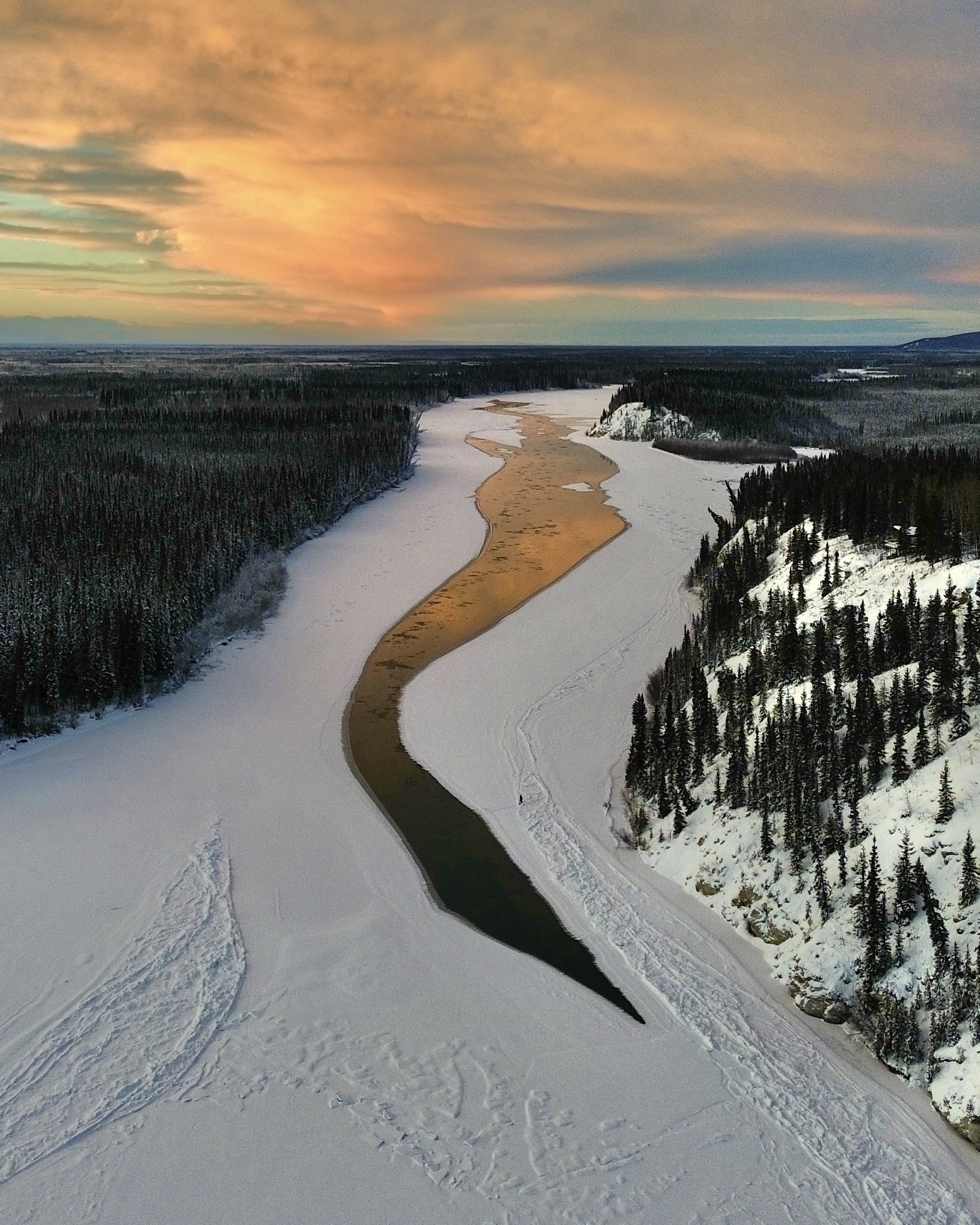 An aerial shot of the frozen Tanana River, showing a large channel of open water.