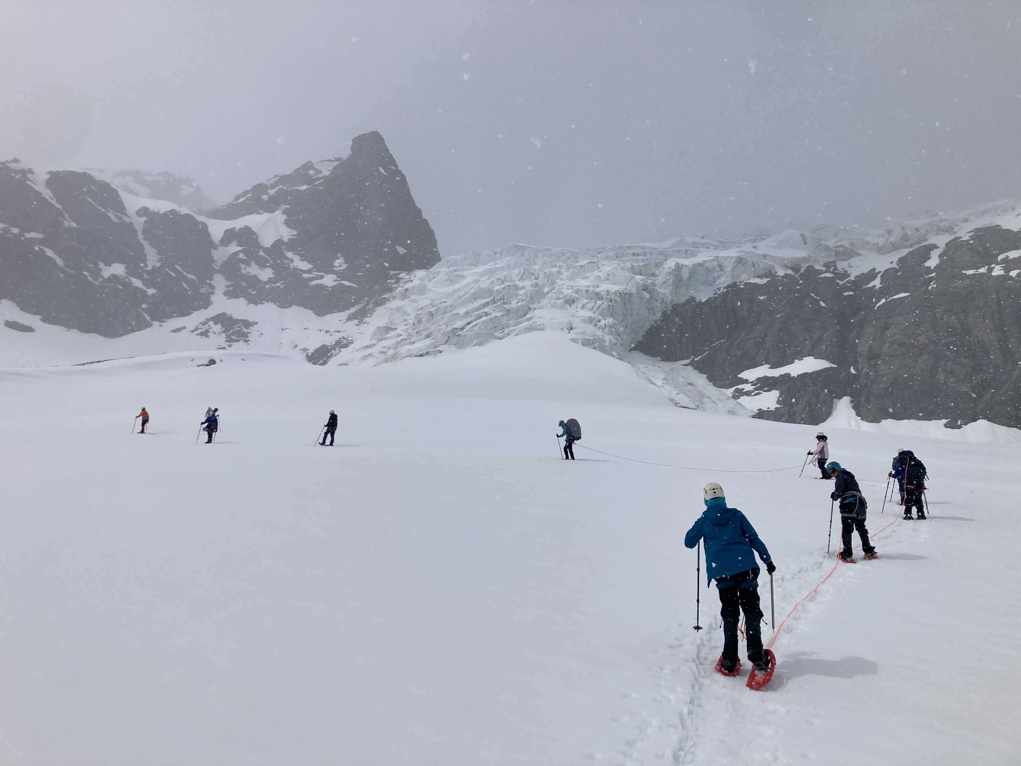 2023 Girls* on Ice Alaska participants traverse a snowfield in the Alaska range.