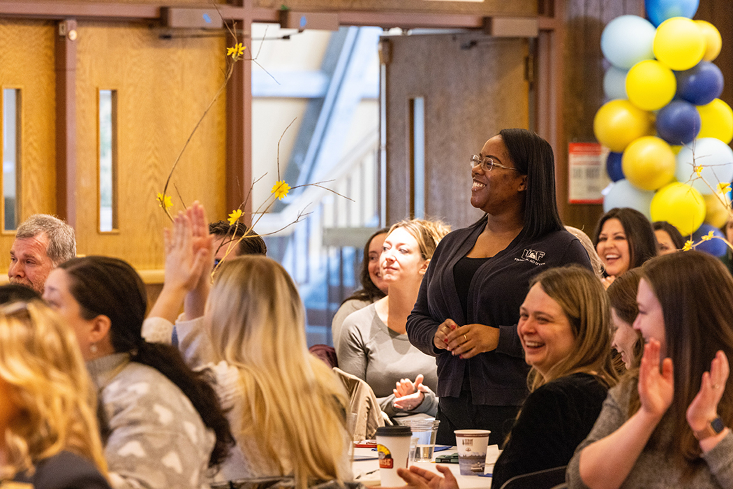 Associate director of Financial Aid, Martika Hubbard, stands to be recognized during the 2025 Longevity Awards.