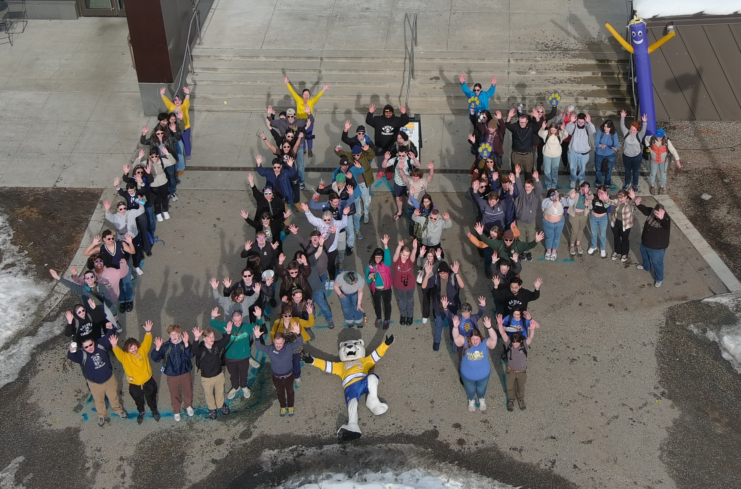An aerial photo of people forming the letters U A F.