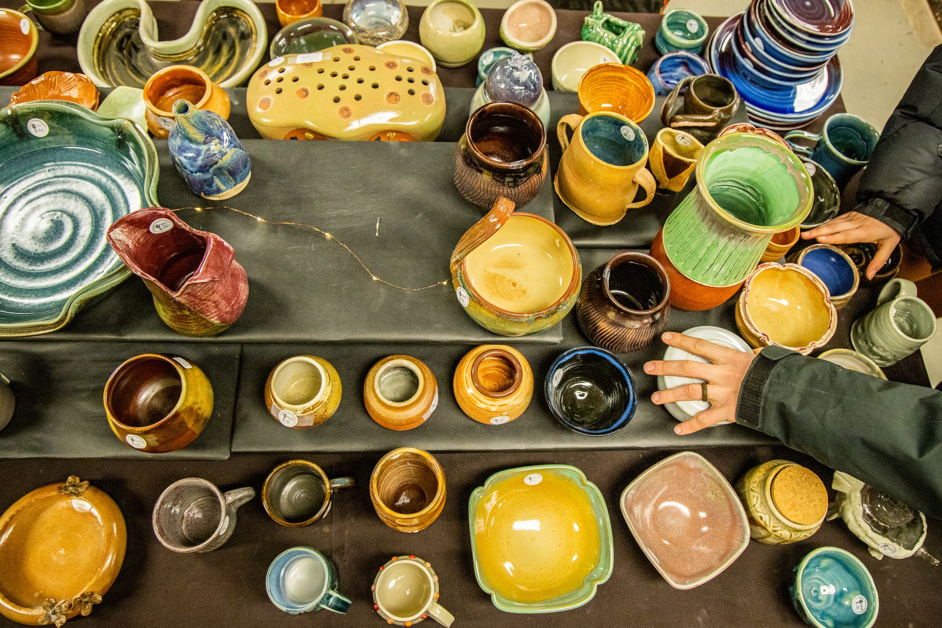 Shoppers browse a variety of pottery at one of the UAF student art sales on the Troth Yeddha' campus.