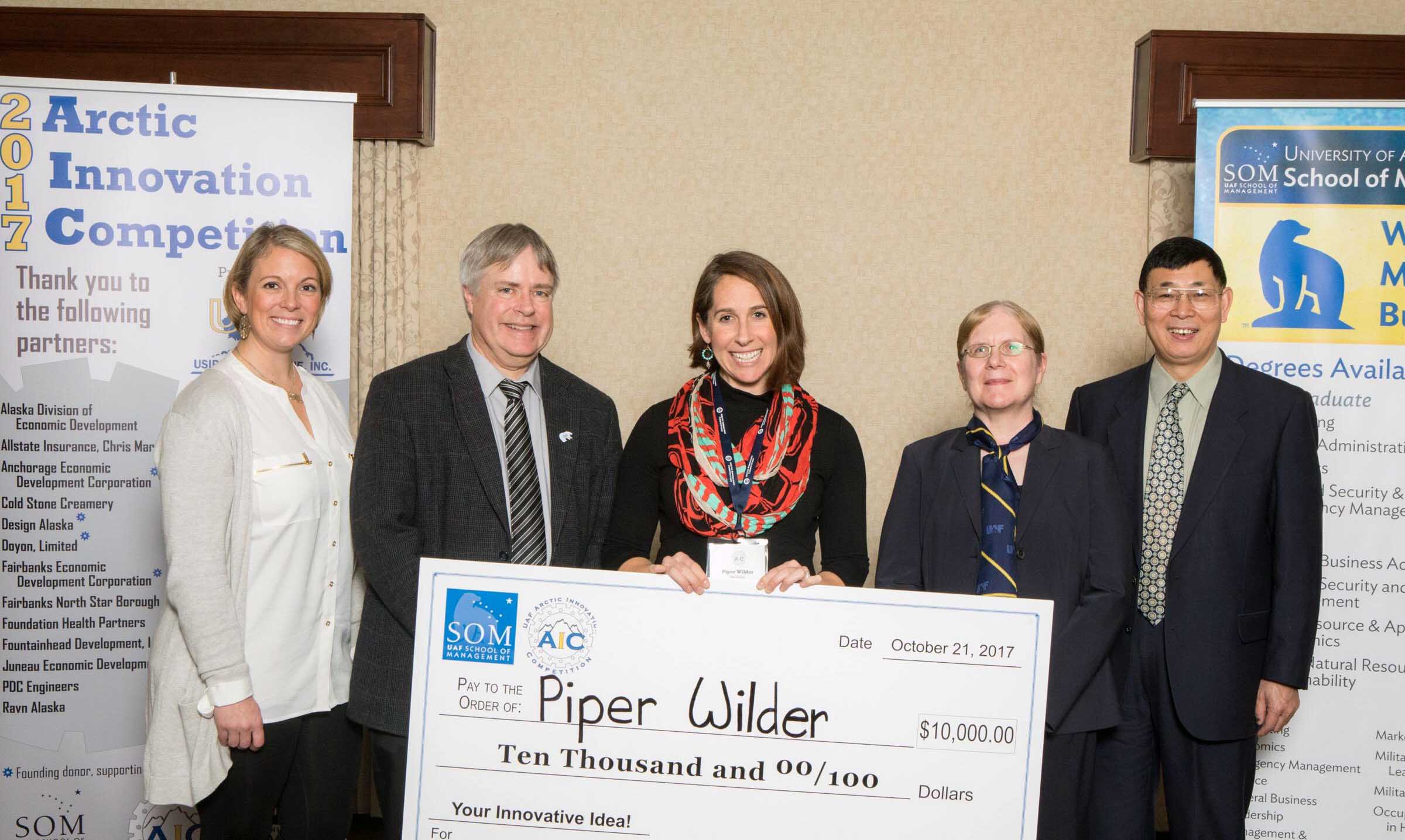 AIC winner Piper Wilder accepts 1st place with 60Hertz Microgrids. Photo by JR Ancheta/UAF.