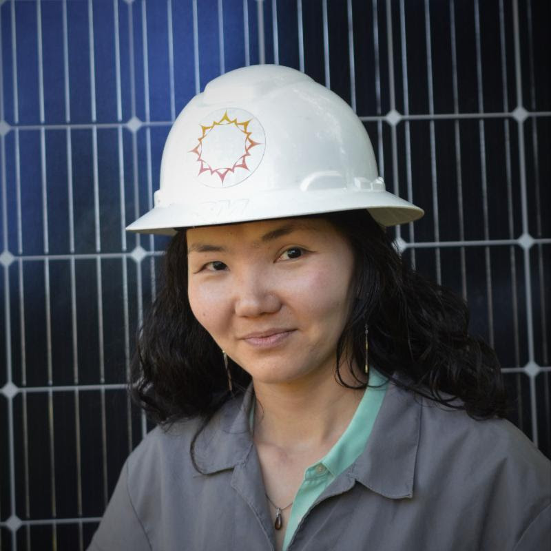 Angie Mendbayar stands in front of a Box Power solar panel. Photo courtesy of BoxPower.
